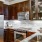 Spacious and well lit kitchen with wood floors and stainless steel appliances. 